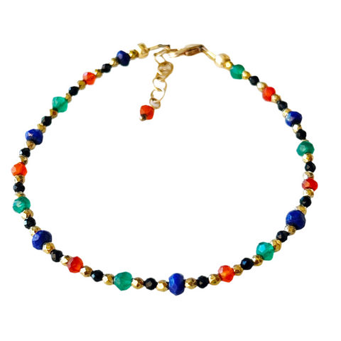 A multicolored beaded bracelet is shown featuring blue lapis lazuli, green onyx, and orange carnelian, interspersed with smaller gold and black spinel beads